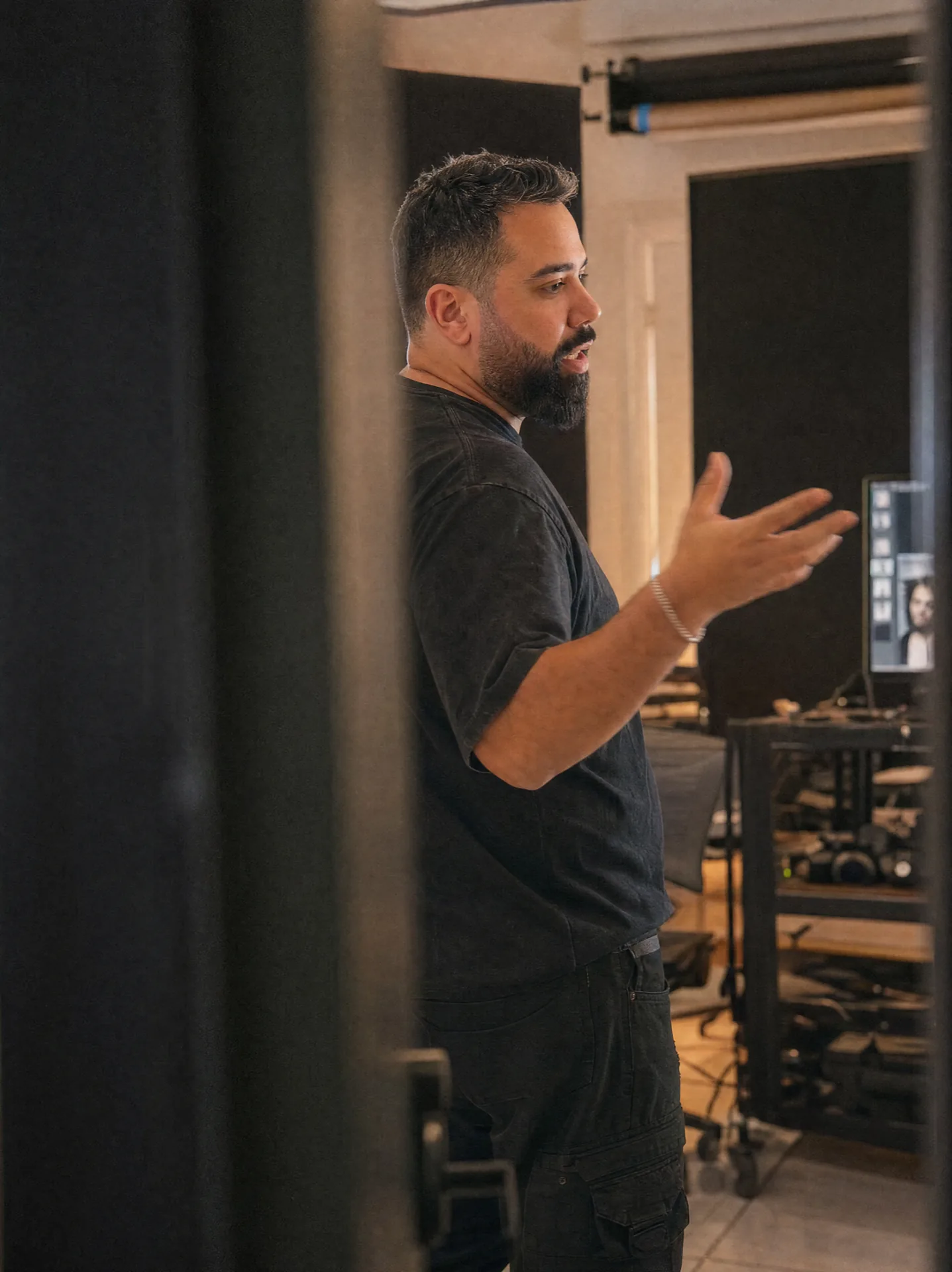Akram in a doorway, directing, mid-thought.