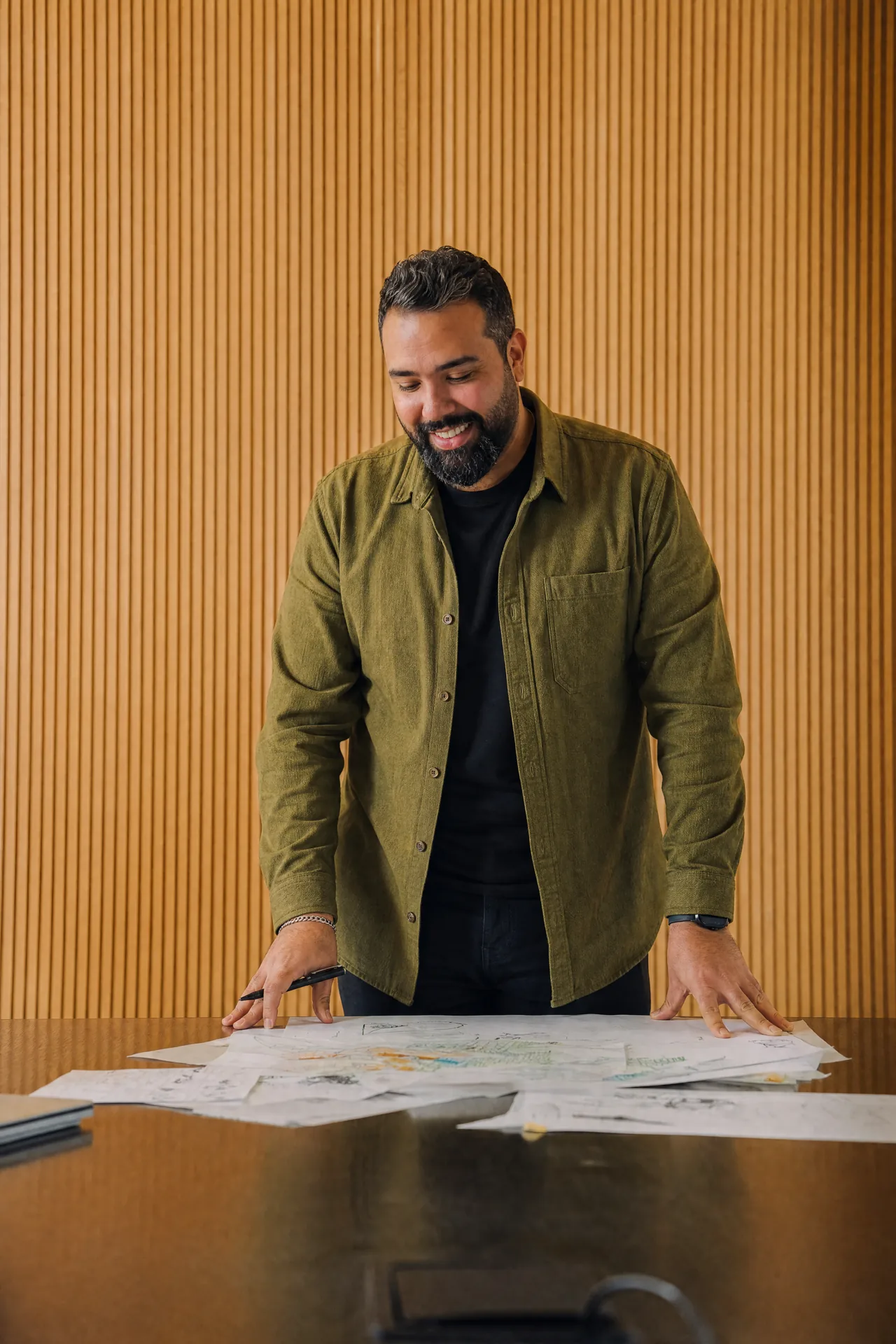 Akram over a spread of printed sketches.